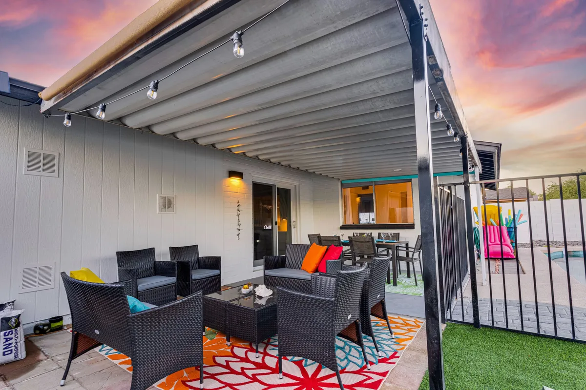 This photo features an inviting outdoor seating area with a colorful rug and cozy chairs, all illuminated by string lights. The setting feels festive and welcoming, ideal for socializing, evening gatherings, or quiet relaxation after a day of adventure.